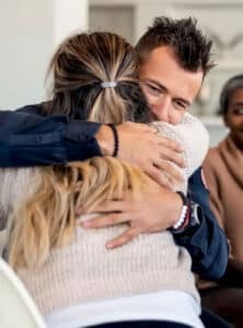 imgi_70_In-a-waiting-room-a-man-hugs-a-woman-ar-the-Compassion-Recovery-Center-in-Laguna-Hills-222x300